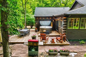 BBQ grill, outdoor dining, hot tub, fire pit, and wooded surroundings
