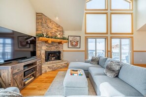 Cozy & modern open concept main living room w/ sectional, 70" TV and fireplace