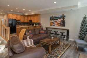 The living room, appointed with comfortable furniture, offers easy access to the outdoor balcony.