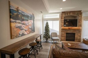 The living room boasts abundant natural light, a welcoming fireplace, and direct access to the balcony.