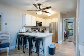 The gourmet kitchen features breakfast bar with seating for four and is equipped with stainless steel appliances, including a microwave, stove, and spacious refrigerator.