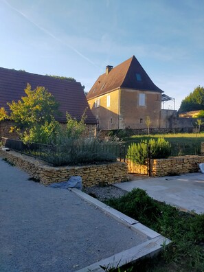 Terrain de pétanque attenant à la piscine. Maison en fond