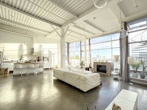 Spacious loft with high ceilings, floor to ceiling windows, concrete floor.
