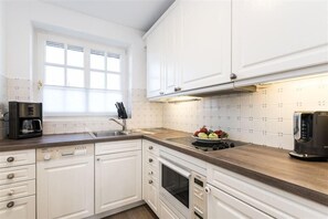 Moderne Küchenzeile mit Backofen, Geschirrspüler, Kaffeemaschine, Wasserkocher und Toaster, in der Wohnung Caterina, Hochkamp 11B in We...