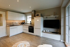 moderne Küchenzeile der Wohnung 5 des Haus Sea Salt im Amselweg 15, in Westerland, mit Geschirrspüler, Backofen, Mikrowelle, Kaffeemasc...