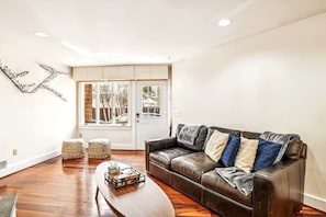 Complemented by earthy tones and natural materials such as wooden floors, this space provides a place to relax, watch TV or even host a game night. 