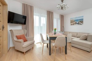 Living area with comfortable sofa bed, dining area and TV.