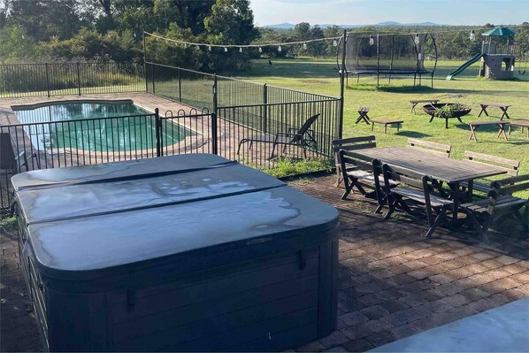 Watch the kids play on the grass and splashing in the pool while you relax in the hot tub and enjoying a glass of wine and cheese platter