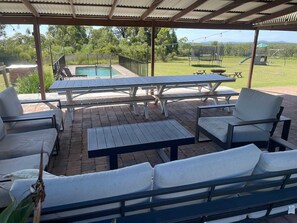16 person covered entertainment area with tables chairs lounge chairs bbq and pizza oven 