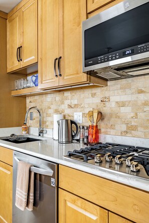 Savor culinary delight in the custom kitchen. SS appliances, gas stove, no oven.