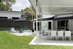 Large fully fenced backyard with undercover dining, lounge and pool