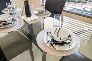 Elegant dining setup ready for your memorable meals. Enjoy a stylish dining experience with modern tableware and abundant natural light