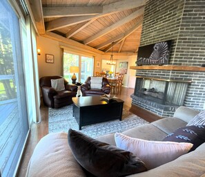Living Room with Balcony and Fireplace Adjacent to Dining Area