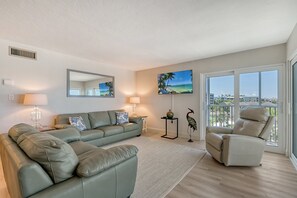Large living room combined with sliders out to wrap-around Lanai - spectacular views of world famous Crescent Beach and the Gulf of Mexico.  Large flat panel HDTV
