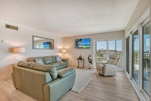 Large living room combined with sliders out to wrap-around Lanai - spectacular views of world famous Crescent Beach and the Gulf of Mexico.  Large flat panel HDTV