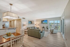 Large living room combined with sliders out to wrap-around Lanai - spectacular views of world famous Crescent Beach and the Gulf of Mexico.  Large flat panel HDTV