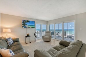 Large living room combined with sliders out to wrap-around Lanai - spectacular views of world famous Crescent Beach and the Gulf of Mexico.  Large flat panel HDTV