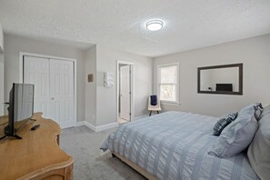 Indulge in luxury in our master bedroom, featuring a luxurious king bed, ample dresser space, flat-screen Roku TV and a sleek en suite bathroom with a walk-in shower.