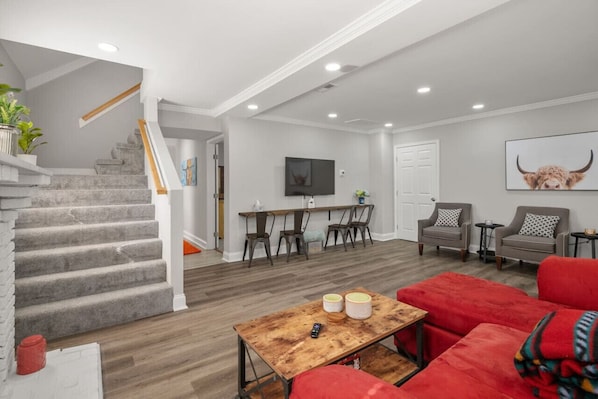 Unwind in our spacious living room, boasting ample seating, games, a flat-screen Roku TV, and additional seating at the floating bar table.