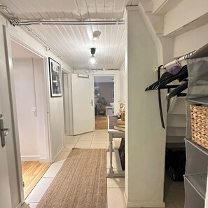 The hallway has a Bluetooth radio, coat rack, and vacuum cleaner.