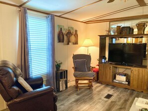 Living room with Roku TV, DVD player, books and games!