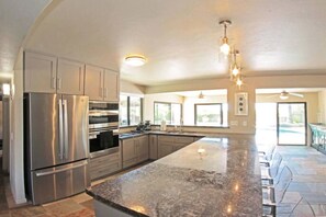 Well-appointed kitchen with stainless steel appliances and backyard views