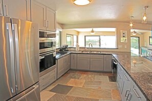 Well-appointed kitchen with stainless steel appliances and views of the backyard