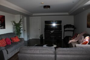 living room with 2 recliner sofas , 1 sofa bed , TV, treadmill