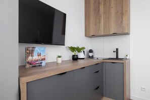 TV in the studio and fully equipped kitchenette with electric hob, fridge, electric kettle and coffee maker (for capsules).