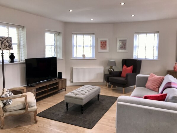Large comfortable sofa and two armchairs with low lights. Smart 55” tv