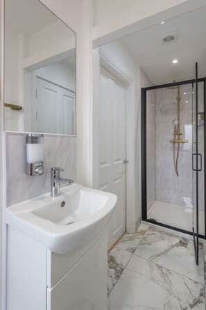 Newly-renovated bathroom in Room 1. It comes with bodywash, shampoo, and conditioner.