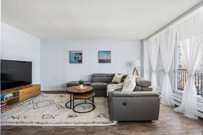 Cozy, luxurious & modern living room with real wood decor, 65" Smart TV with Netflix and Cable TV to enjoy your sports, news and more!