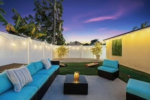 The backyard seating set comfortably accommodates 6 people and features cornhole and mini putting on artificial grass.