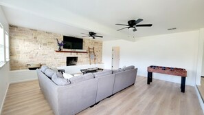 Living Room, w/ TV, fireplace, Big couch, and foosball table.