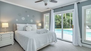 Comfortable bedroom with a king-sized bed and sliding glass doors leading to a poolside patio