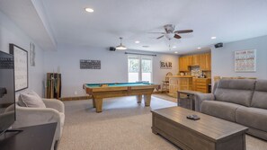 Entertainment room with a pool table, a wet bar, and comfortable seating