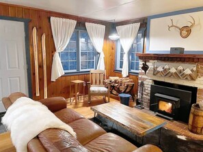 Warm and inviting living space with a wood-burning fireplace and rustic touches for a homey feel.