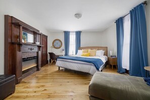 Unwind in the spacious master bedroom featuring a king bed and an electric fireplace for added coziness.