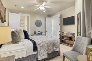Main Bedroom Side View - The main bedroom is furnished with a plush King bed, private TV, and walk-in closet.