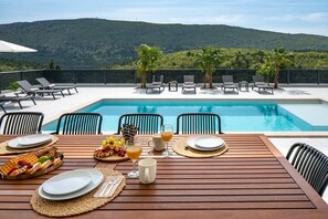 A covered outdoor dining table with seating for ten people
