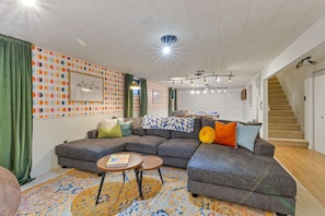 This living room is in an open concept area with the game room