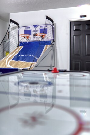 Basketball and air hockey table. Lounge area in game room with UNO cards. 