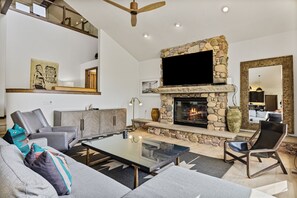 Large Living Room Featuring Stone Fireplace and Flat Screen TV.