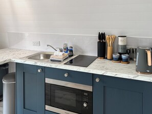 Kitchen fitted with microwave, oven, kettle, toaster, fridge, small freezer | Bombie Glamping pod, Cromdale, near Grantown-on-Spey