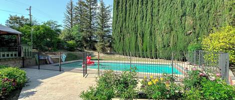 Gated pool with lounge chairs and shaded area