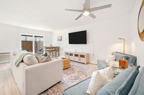 The living room features a queen-size sofa bed along with two single sofa beds and a TV.