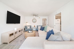 The living room features a queen-size sofa bed along with two single sofa beds and a TV.