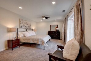 Beautiful, spacious Main Bedroom w/King bed, dresser, bedside table, lamp, chair.