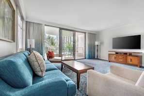 Living room features a sleeper sofa and a door to the furnished patio.