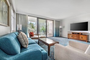 Living room features a sleeper sofa and a door to the furnished patio.